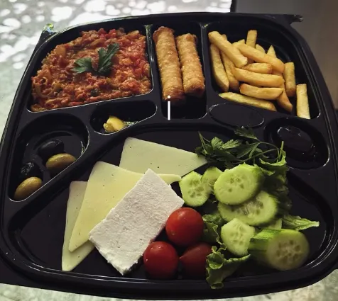 Peynir, zeytin, domates ve salatalıkla sunulan kahvaltı tabağı
