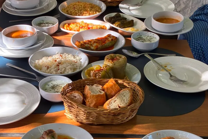 Dolma’da çorba, pilav, dolma ve ev yemekleriyle kurulmuş ahşap masa